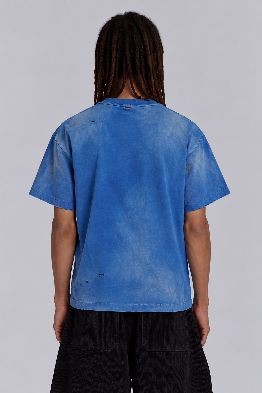 Back view of washed-blue oversized tee with distressed detailing